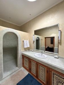 een badkamer met een wastafel en een spiegel bij Palais Claudio Bravo in Taroudant