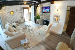 a living room with a couch and chairs and a fireplace at Le petit cocon de Chateau Chalon in Château-Chalon