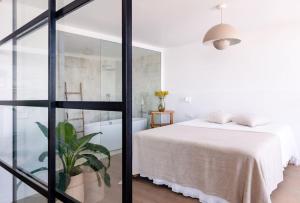 1 dormitorio con cama blanca y bañera en Diamond Suite Bajamar, en Bajamar