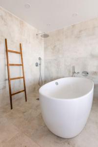 ein Badezimmer mit einer großen weißen Badewanne und einer Leiter in der Unterkunft Diamond Suite Bajamar in Bajamar