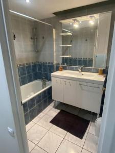 ピュトーにあるTour Défense 2000 Magnifique Appartementの洗面台、浴槽、鏡のあるバスルーム +26枚の写真