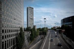 a highway in a city with a tall building at Tour Défense 2000 Magnifique Appartement in Puteaux