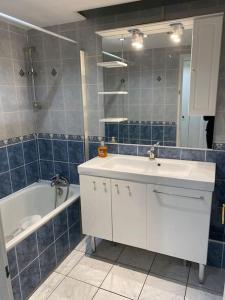 ピュトーにあるTour Défense 2000 Magnifique Appartementのバスルーム(白いシンク、バスタブ、鏡付)