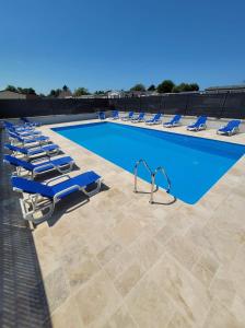 - une piscine bordée de chaises longues bleues dans l'établissement Mobil home-Les Lins Bleus, à Biville-sur-Mer