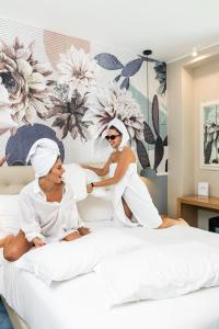 Dos mujeres en toallas sentadas en una cama en Hotel Sogaris, en Paestum