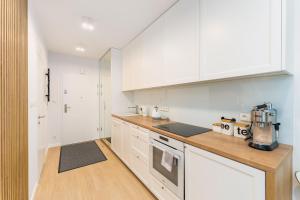 a kitchen with white cabinets and a counter top at Beachmee Condo Rogowo in Rogowo