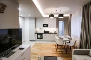 kuchnia i salon ze stołem i krzesłami w obiekcie D Apartments Centrum Powietrze w mieście Białystok