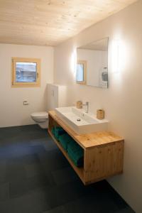 a bathroom with a white sink and a toilet at La Grobla - Die ruhige & heimelige Ferienwohnung in Zillis