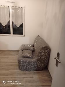 un sofá sentado en una esquina de una habitación en La maison du midi, en Cérans-Foulletourte