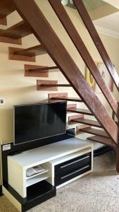 阿拉亞爾多卡博的住宿－Bilico Aluguel de Cobertura，客厅设有平面电视和楼梯。