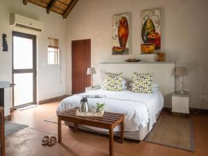 1 dormitorio con cama blanca y mesa en Mohlabetsi Safari Lodge, en Hoedspruit