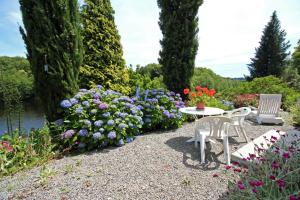 Compreignac的住宿－Dominant l'etang，花园里种满鲜花,配有桌椅