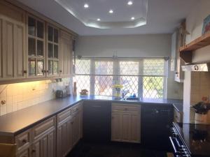 a kitchen with white cabinets and a black counter top at Crow’s Nest, Central New Forest coastal village beach apartment in Milford on Sea