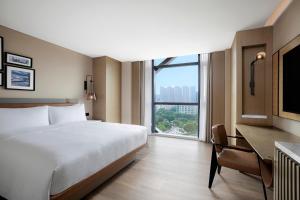 een hotelkamer met een bed, een bureau en een raam bij Four Points by Sheraton Shenzhen Bao'an in Shenzhen