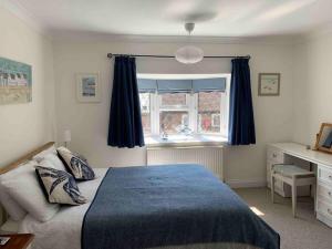 a bedroom with a bed and a window at Crow’s Nest, Central New Forest coastal village beach apartment in Milford on Sea