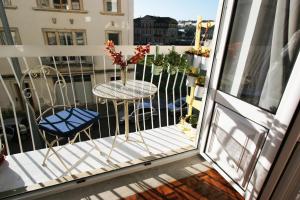 a balcony with a table and chairs on a balcony at Oleiros Rooms City Center in Coimbra