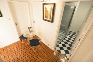 a hallway with a table and a checkered floor at Oleiros Rooms City Center in Coimbra