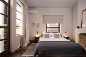 a bedroom with a large bed with two windows at Villa Meliti in Athens