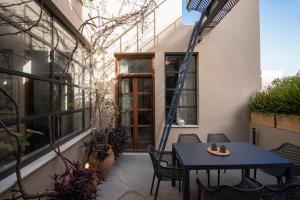 雅典的住宿－梅利蒂別墅，一个带桌椅的庭院和一座建筑