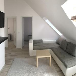 uma sala de estar branca com um sofá e uma mesa em Villa Oliver Balatonlelle em Balatonlelle