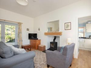 a living room with two couches and a fireplace at Nettlebush Cottage-uk5629 in Drummelzier
