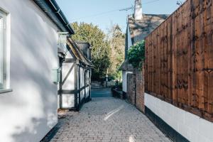 Stable Mews, Prestbury Cheltenham في Southam: زقاق بين مبنيين في مدينة