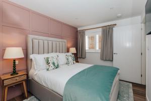 a bedroom with a large bed and a window at Stable Mews, Prestbury Cheltenham in Southam