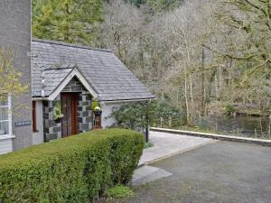 a house with a hedge next to a driveway at Trem Yr Ynys in Betws-y-coed