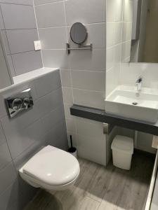 La salle de bains est pourvue de toilettes blanches et d'un lavabo. dans l'établissement Superbe studio, terrasse, piscine, parking, au Grau-du-Roi