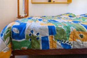a bed with a colorful quilt on top of it at Appartement Chabrières in Réallon