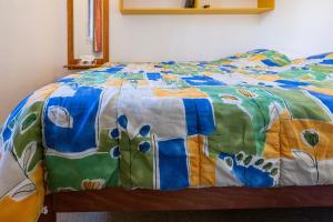 łóżko z kolorową kołdrą w obiekcie Appartement Chabrières w mieście Réallon