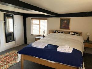 1 dormitorio con 1 cama con 2 toallas en Charming holiday apartment in central Woodbridge, en Woodbridge