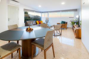 a dining room and living room with a table and chairs at Estancia Lucía in La Orotava