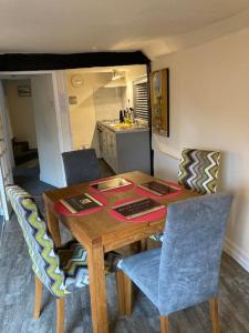 a dining room table with chairs and a kitchen at Charming holiday apartment in central Woodbridge in Woodbridge