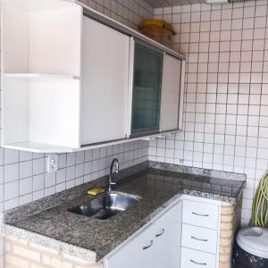 cocina con fregadero y armarios blancos en Bilico Aluguel de Cobertura, en Arraial do Cabo