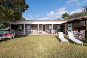 dom z dziedzińcem z krzesłami i patio w obiekcie Villa Cortesia Maritima - seaside & private w mieście Amarynthos