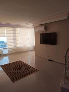 a living room with a flat screen tv on the wall at Alanya Bektaslar 3+1 lüks daire in Alanya