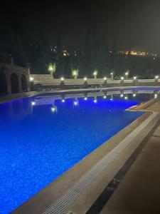a large swimming pool with blue water at night at Alanya Bektaslar 3+1 lüks daire in Alanya