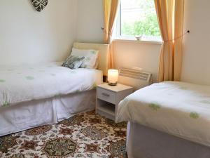 a bedroom with two beds and a window at Cedar in Thornbury
