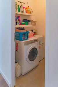 a laundry room with a washing machine and shelves at Prachtig & ruim luxe appartement in Bruges