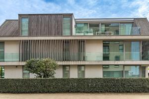 a large building with windows and a hedge at Prachtig & ruim luxe appartement in Bruges