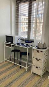 a kitchen with a table with a microwave and two stools at Viehättävä asunto Heinolan keskustassa in Heinola