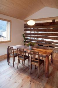 a dining room with a wooden table and chairs at La Grobla - Die ruhige & heimelige Ferienwohnung in Zillis