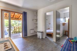ein Wohnzimmer mit einem Schlafzimmer und einem Balkon in der Unterkunft Village Vacances La Forêt des Landes in Tarnos