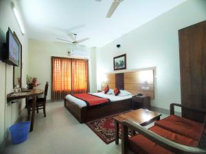 a hotel room with a bed and a table and a couch at Hotel Supreme in Sylhet