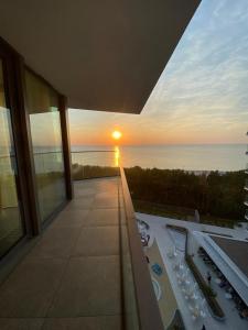einen Blick auf den Sonnenuntergang vom Balkon eines Gebäudes in der Unterkunft Wave De Luxe Studio Resort&SPA 755B - Sea View in Misdroy