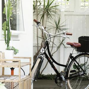 a bike parked on a porch with plants at The White Cottage Byron Bay in Suffolk Park