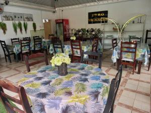 a dining room with a table with flowers on it at Euro Vacances Guest House in Roches Brunes