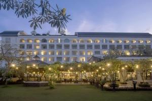 a large white building with a courtyard at night at Grand Rohan Jogja in Yogyakarta