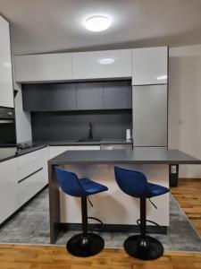 kuchnia z 2 niebieskimi krzesłami przy ladzie w obiekcie Apartman Šćuric w Zagrzebiu